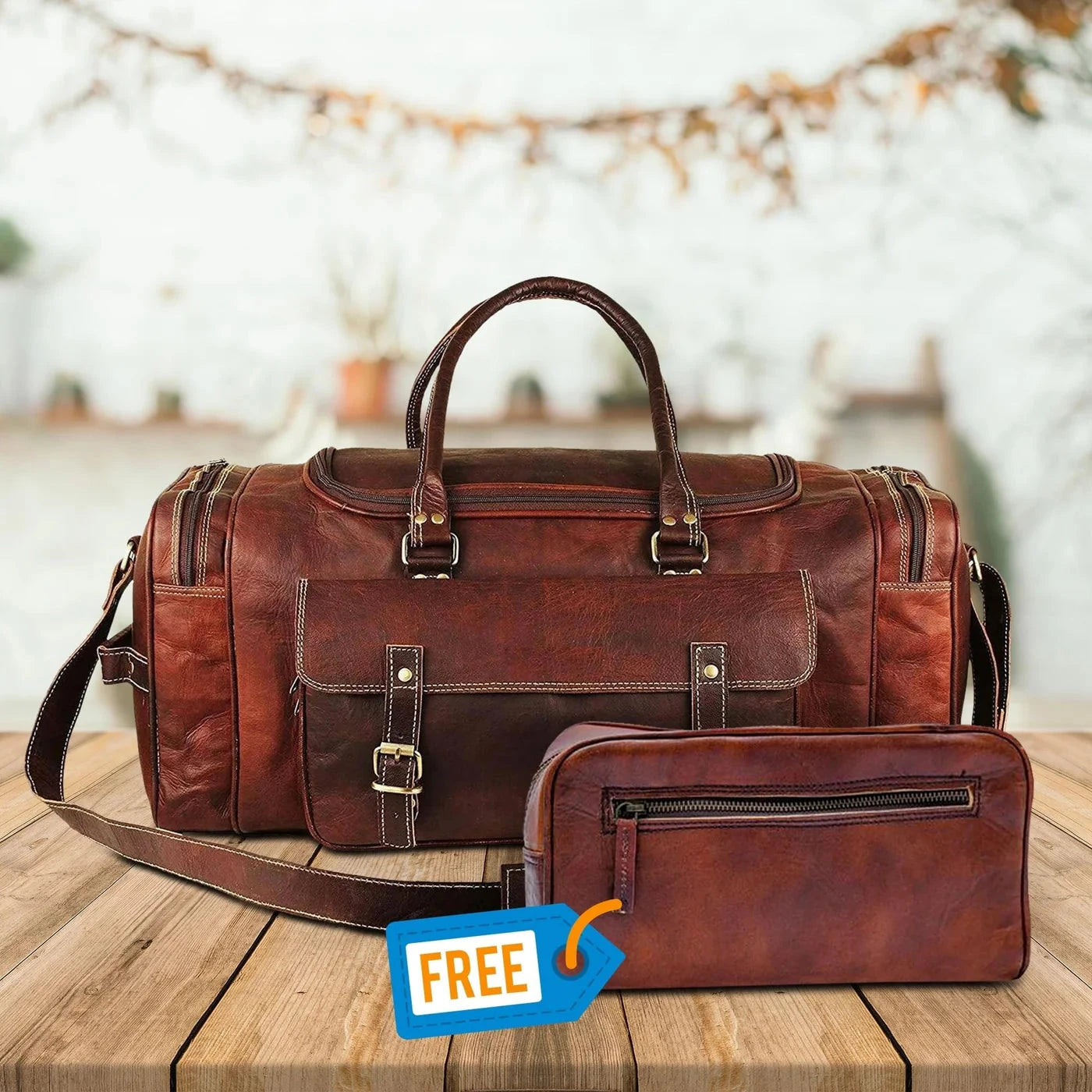 Brown leather duffel bag and pouch with a 'Free' tag on a wooden surface.