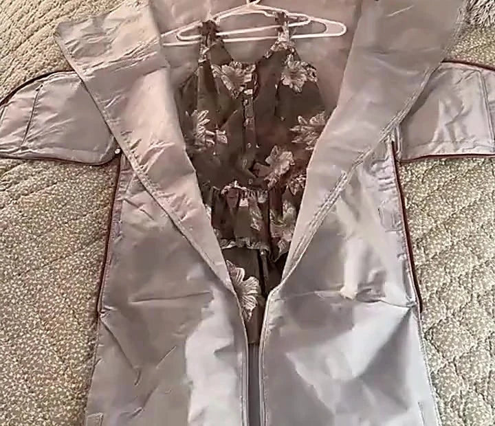 The garment compartment of the Vohxe Travel Bag 2.0 laid flat on a bed with a dress hanging from the built-in hanger
