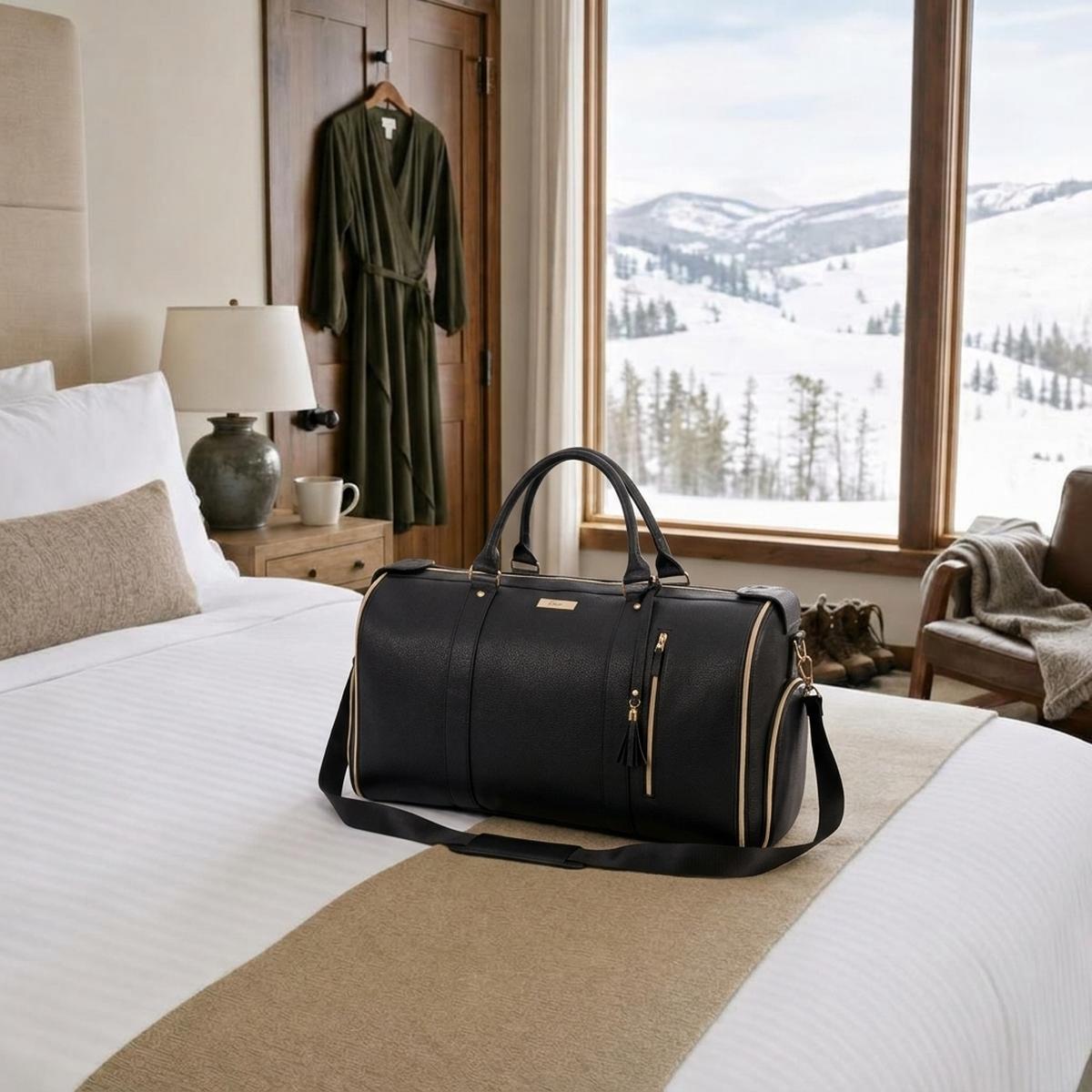 The charcoal black Vohxe Travel Bag packed and settled in a cozy Montana mountain lodge bedroom