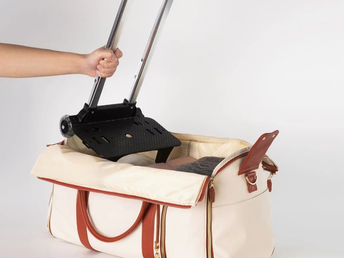 The bag open on a bed, packed with a week and a half of folded clothes and a dress hung flat