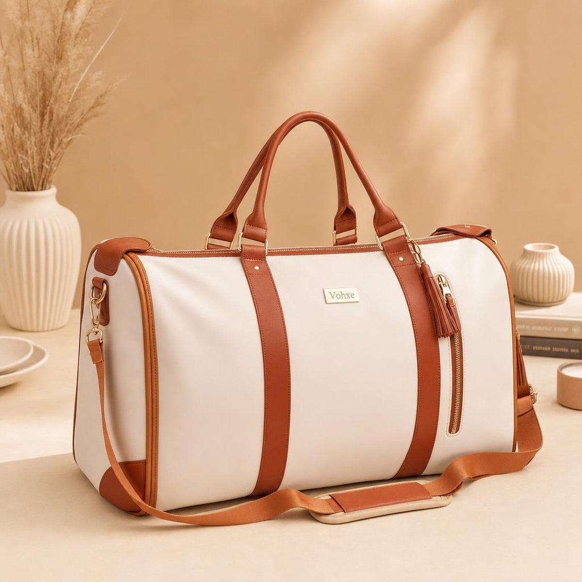 The Vohxe travel bag in soft leather with a long shoulder strap and brass hardware