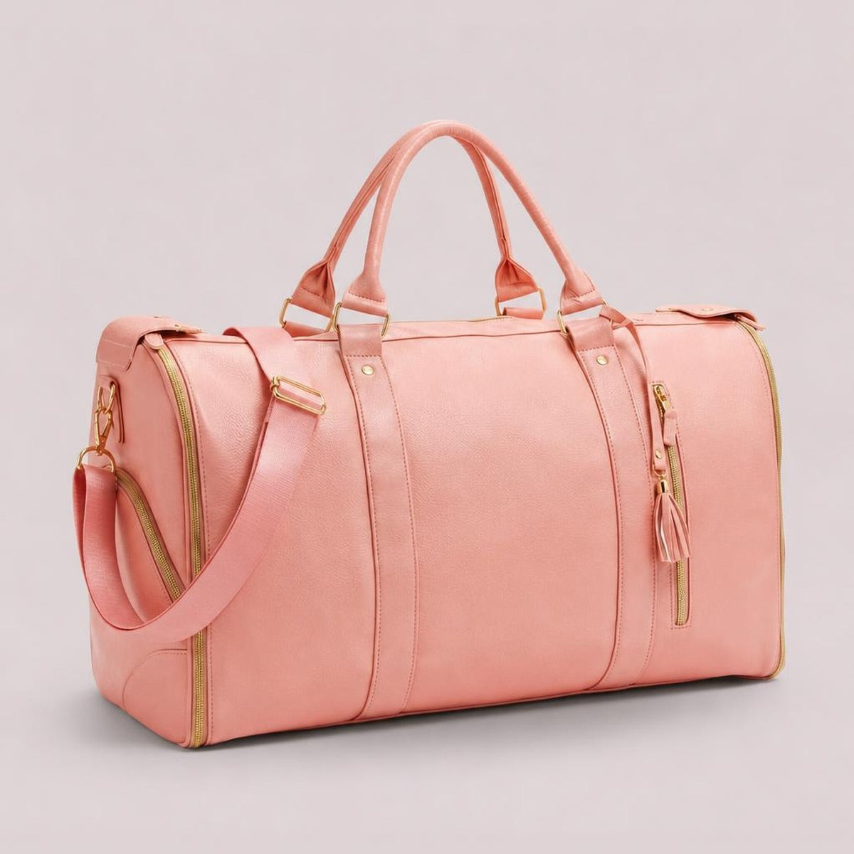 The rose pink Vohxe Travel Bag 2.0 standing upright, soft leather with gold zippers and detachable strap